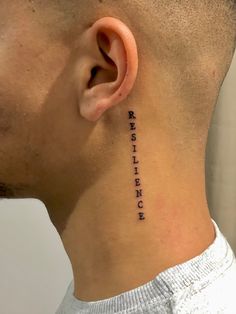 a man's neck with an ear tattoo that says strength