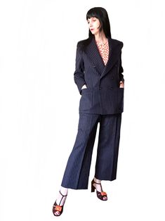 "a  vintage 1970s French Designer blue wool pant suit by Pierre Cardin this stylish two piece suit is made of navy blue wool with a white pinstripe. this beautifully tailored suit features a large pointy lapel, double row black buttons, large front pockets, shoulder pads. jacket is lined with blue rayon fabric. it has shoulder pads high waisted pants with metal zipper and hook Label :Pierre Cardin Boutique label : designed in Paris, made in Colombia Unisex Perfect for any occasion dressed up or Tailored Suit, Pinstripe Suit, Blazer Designs, French Designer, Wedding Suit, Pant Suit, Wedding Suits Men, Wool Pants, Pierre Cardin