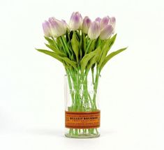 a vase filled with purple flowers on top of a white table