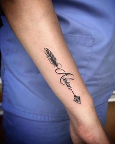 a person with a tattoo on their arm that has an arrow and the word love written in cursive writing