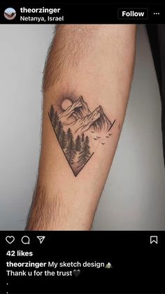 a woman's arm with a mountain scene tattoo on the left side of her arm