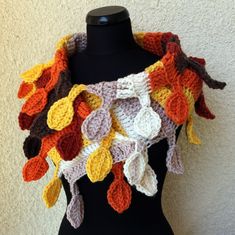 a crocheted scarf on a mannequin's torso, with leaves hanging from it