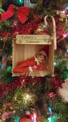 a christmas tree with an elf doll in a box