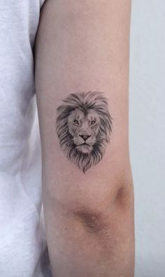 a small lion tattoo on the arm