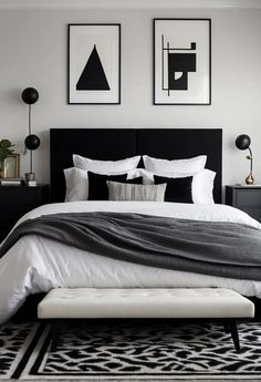 a black and white bedroom with pictures above the bed