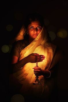 a woman holding a candle in her hands