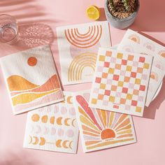 four napkins on a pink surface with an orange and yellow design in the middle