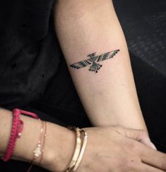 a woman's arm with a tattoo on it that has an eagle in the middle