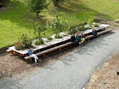 several people sitting on benches in the middle of a park