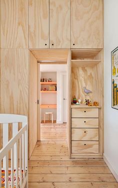 a baby's room with wooden walls and drawers