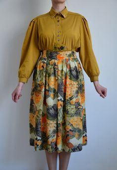 Vintage floral print midi skirt from the 90s. Women's high waist boho skirt with floral print in earthy tones - orange, olive green, brown. The skirt has elastic on the waist, closes with a zipper on the back and falls free below the knees. Material: skirt is 100% Viscose, lining is 100% Polyester Size; 38 DE, which is 8 US or M. Model shown on the photos wears 38 DE / 8 US / M. To be sure this item would fit you, please check the measurements below. Approximate Measurements ( taken when skirt lying flat, double waist and hips) Waist (double that): Stretches from 14 inches / 35.5 cm up to 16 inches / 40.6 cm  Length: 30 inches / 76.2 cm Condition: Excellent vintage condition! Has been shortened by previous owner (please refer to the last photo). This listing includes the skirt, you can see Retro Floral Print Skirt, Spring Vintage Lined Maxi Skirt, Vintage Lined Maxi Skirt For Spring, Vintage Full Maxi Skirt For Spring, Retro Floral Print Skirt With Relaxed Fit, Retro High-waisted Skirt For Spring, Retro Long Skirt With Floral Print, Vintage High-waist Skirt For Spring, Vintage Flowy Skirt Bottoms With Floral Print