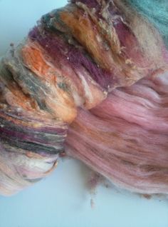 two skeins of dyed wool on a white surface