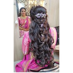 a woman is getting her hair done in the mirror and looking at herself in the mirror