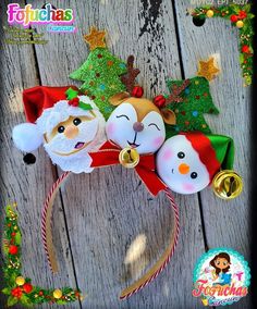 two stuffed animals wearing santa hats on top of a wooden surface with christmas decorations around them