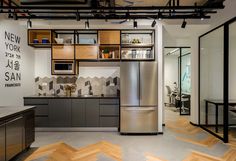 an industrial kitchen with stainless steel appliances and wood flooring, along with open shelving