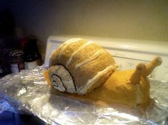 a stuffed animal that is laying down on some tin foil in front of a dryer