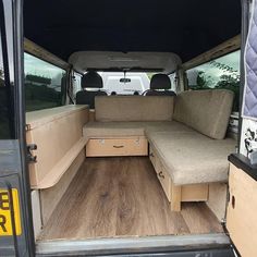 the interior of an empty van with wood flooring and storage drawers on the side