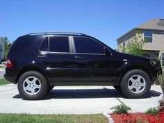 a black suv parked in front of a house