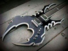 a black and white guitar sitting on top of a wooden table