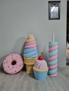 three ice cream cones, two donuts and one strawberry are sitting on the floor