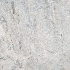 a white marble textured surface with grey veinies