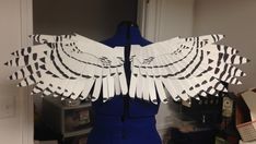 a mannequin with white paper wings on it