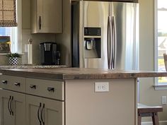 a kitchen with stainless steel appliances and wooden counter tops, along with an island in the middle