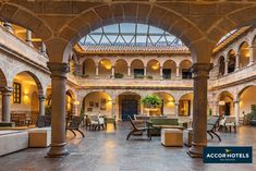 the inside of a hotel lobby with tables and chairs