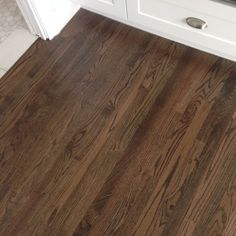 a kitchen with white cabinets and wood flooring