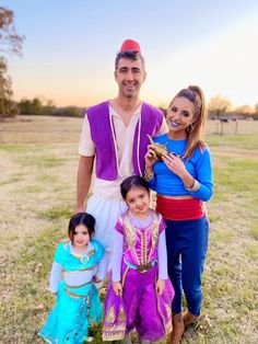 a man and two girls standing next to each other in front of an open field