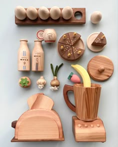 various wooden objects are arranged on a blue surface, including an egg carton and other kitchen utensils