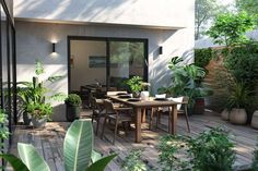 an outdoor dining area with potted plants on the deck and wooden table surrounded by greenery