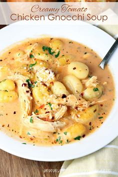 a white bowl filled with chicken gnocchi soup on top of a wooden table