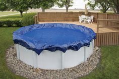 an above ground swimming pool covered with a blue tarp in the middle of a yard