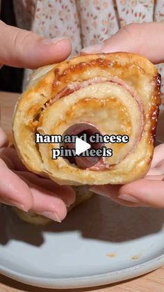 two hands holding up a ham and cheese pinwheel on a white plate with the words ham and cheese pinwheels