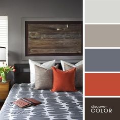 a bedroom with gray and orange colors in the bedding, pillows, and decor