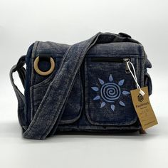 Puzzlestack’s Lukla Blue Stone-Washed Embroidered Messenger Bag Is A Compact Yet Voluminous Bag. Along With Its Multiple Pockets Used For Storage, It Includes A Large Flap Closure With Velcro. Starting Off With The Two Front Pockets, Open Up The Flap To Find The Main Compartment Following The Large Extra Pocket, And Even A Cute Mini Side Pocket! Make Travel Hands-Free With This Spacious Bag. Express Yourself With 5 Different Hand-Embroidered Thread Designs To Choose From! Not Only Is This Bag Su Eco-friendly Blue Shoulder Bag With Pockets, Blue Embroidered Everyday Bag, Blue Embroidered Everyday Shoulder Bag, Embroidered Tote Bag, Embroidered Tote, Sustainable Gifts, Purse Accessories, Embroidered Design, Blue Stone