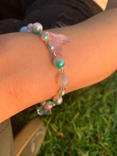 This beautiful, one-of-a-kind bracelet is made with wire, plastic beads, and glass seed beads. It's perfect for any mermaid or ocean lover, and makes a great statement piece. Perfect for anyone who loves the ocean, mermaids, or pretty things! Please use addon 'tracked shipping' to add on a tracked shipping option for $10 additional (shipping be expensive yo) Mermaid Beads Bracelet, Mermaid Core Bracelet, Ocean-inspired Beaded Bracelets With Round Beads, Adjustable Ocean-inspired Beaded Bracelets With Lobster Clasp, Ocean-inspired Beaded Round Bead Bracelets, Ocean-inspired Beaded Round Bracelets, Sea Beads Bracelet, Ocean-inspired Beaded Bracelet Jewelry, Silver Beaded Ocean-inspired Bracelets