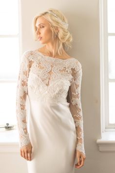 Our CAMERON COVER UP is a versatile addition to your bridal look. This long sleeve, sheer lace top features delicate hand-embroidered lace adorned with pearly seed beads and crystals. This sophisticated piece boasts a ballet neckline and a deep v-neck back, adding a touch of elegance. Perfect to wear as a wedding dress topper or as a crop top with a separate skirt.  *  Off White Hand Embroidered Scallop Lace with off white seed beads, sequins and crystals *  Made of Off White Stretch Mesh Base Fabric *  Available in XS, S, M, L, XL, See last image for Size Chart *  Hook & Eye Closure at Back *  Ships in 4-8 Weeks *  RUSH processing of 3-4 weeks is available for an additional $50 in dropdown options. *  This item is FINAL SALE as it is made to order. 🛒SHOP THE LOOK AND RELATED PRODUCTS * Wedding Dress Crop Top, Crop Top Wedding Dress, Wedding Sleeves, Wedding Dress Topper, Dress Crop Top, Long Sleeve Lace Top, Dress Topper, Hand Beaded Lace, Wedding Bolero