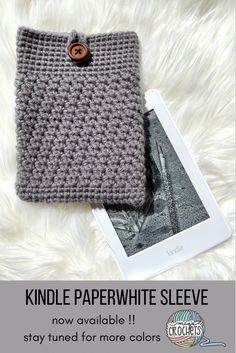 a knitted ipad case sitting on top of a white furnishce with the text, kindle paperwhite sleeve now available stay tuned for more colors