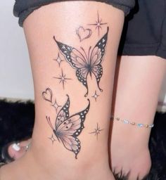 a woman's lower leg with two butterflies and hearts on the back of her body