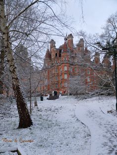 an old building in the middle of winter with snow on the ground and trees around it