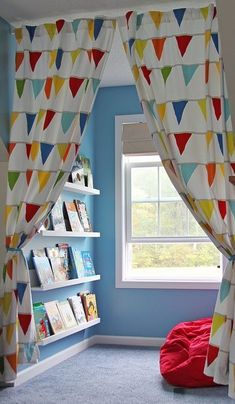 a child's bedroom with colorful curtains and bookshelves