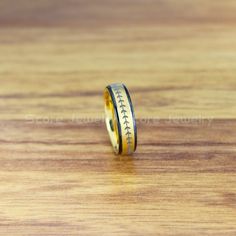 a ring with the word baseball engraved on it sits on a wooden surface, ready to be worn