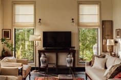 a living room filled with furniture and large windows