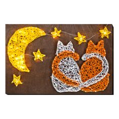 the string art fox is sitting on the table next to the moon and star lights