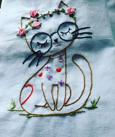 a close up of a piece of cloth with a cat and flower design on it