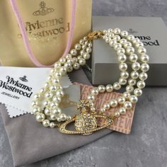 "Vivienne Westwood Three Row Pearl Bas Relief Choker In Gold Brand New, Never Worn, Nwt 100% Authentic Comes With Gift Box, Gift Bag, And Dust Bag Necklace Packed In Secure Packaging For Transit Perfected In Gold Toned Brass, The Three Row Pearl Bas Relief Choker Revisits An Iconic Vivienne Westwood Collection, Dating Back Decades. Featuring Three Hand Knotted Rows Of Swarovski Pearls Meeting Together At A Branded Closure At The Back, The Necklace Is Complimented With The Signature Gold Orb, Ele Iconic Vivienne Westwood, Vivienne Westwood Collection, Vivienne Westwood Bracelet, Vivienne Westwood Earrings, Vivienne Westwood Jewelry, Orb Necklace, Vivienne Westwood Jewellery, Bag Necklace, Saturn Necklace