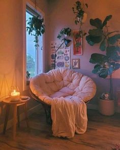 a living room filled with lots of plants next to a window and a chair on the floor