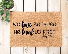 a door mat that says, we love because he loved us first